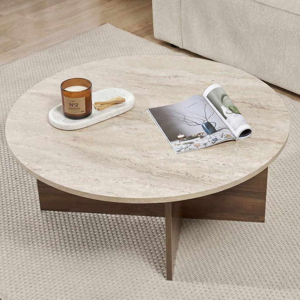 Ronde salontafel met travertin blad en donker houten onderstel in kruisvorm.